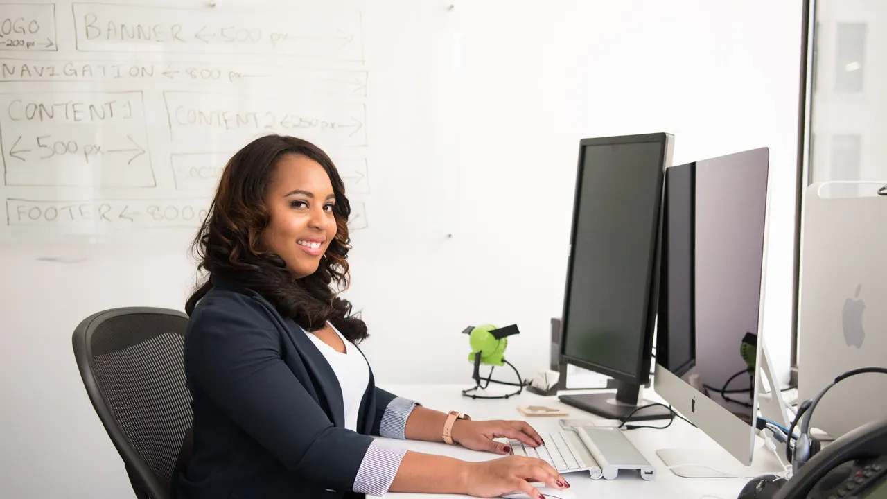 Professionnelle africaine travaillant sur un écran dans un bureau moderne